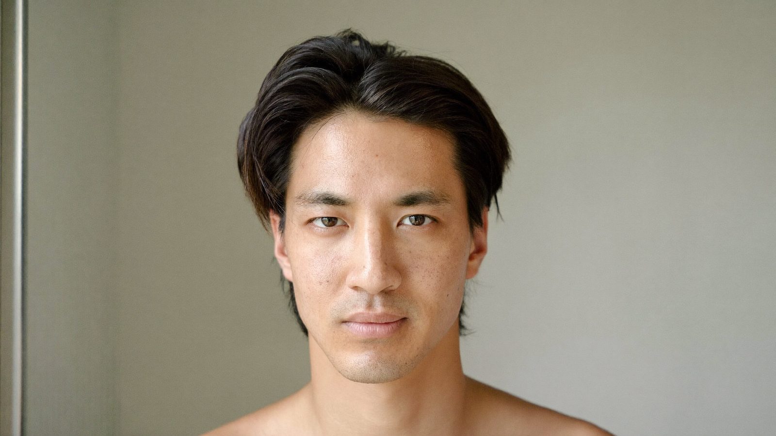 Portrait of a man in his 30s with dark hair swept back from his hairline