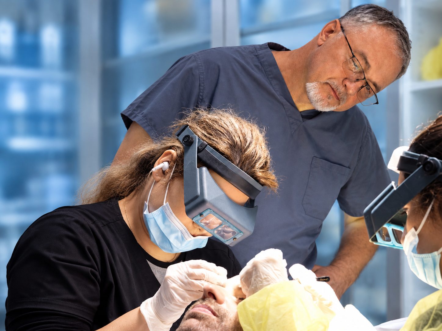 A technician in magnifying loupes places grafts under the oversight of Dr. Val Prokurat, MD at Nova Medical Philadelphia